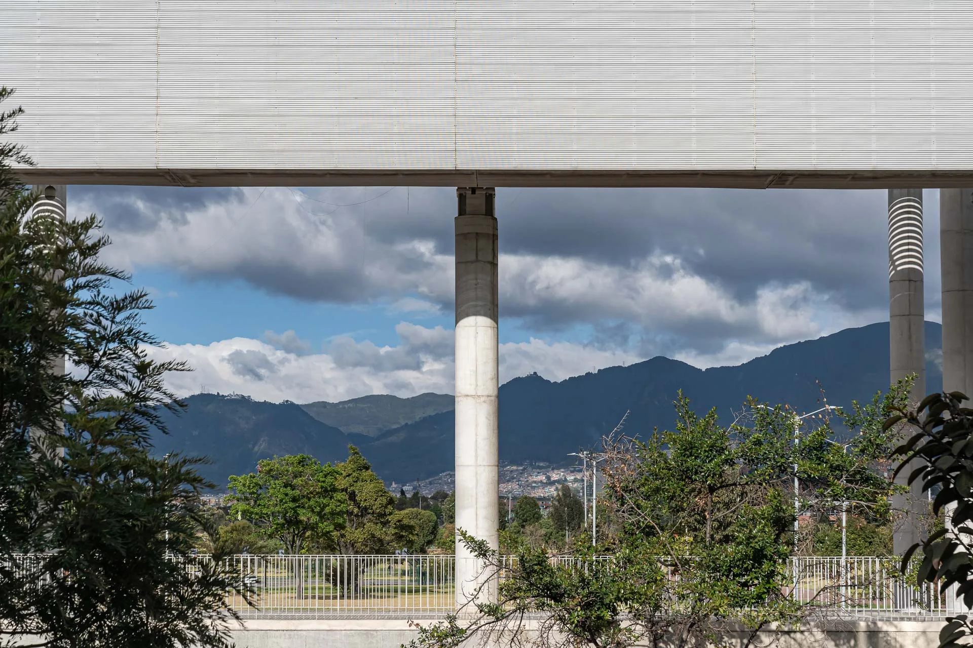 Gimnasio interior con estructura de concreto visto y grandes ventanales perimetrales.